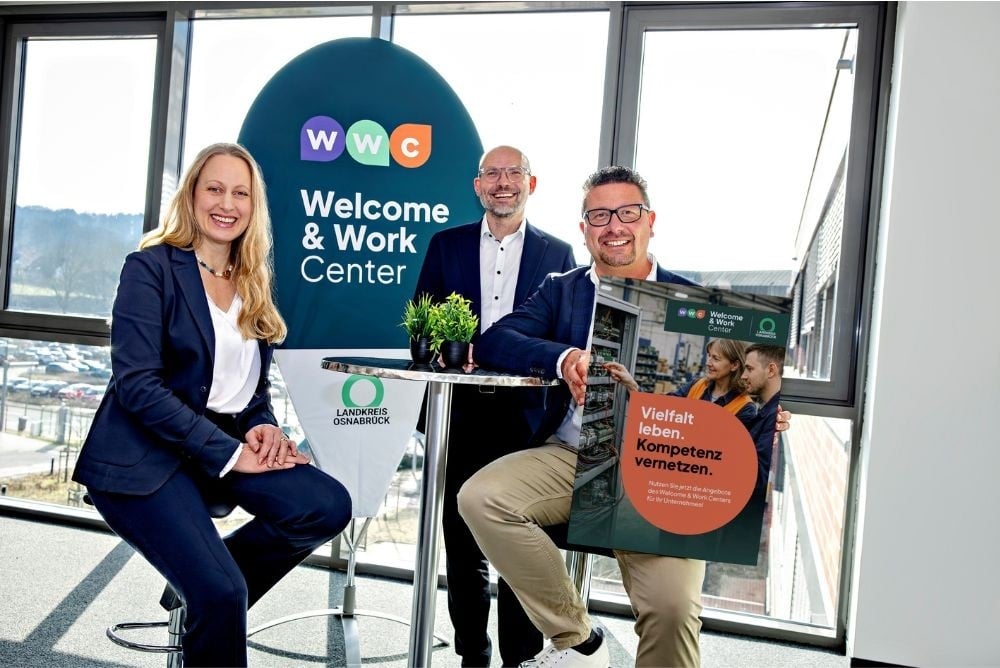 Landrätin Anna Kebschull, WIGOS Geschäftsführer Peter Vahrenkamp und MaßArbeit-Vorstand Lars Helmers stehen vor dem Banner des WWC Welcome & Work Centers des Landkreises Osnabrück.